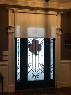 the front door is decorated with an iron gate and glass paneling, along with a rug on the floor