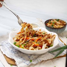 a bowl filled with noodles and meat on top of a table