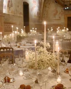 a table with candles and flowers on it in a fancy setting for an event or wedding