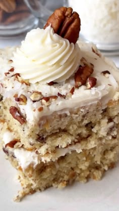 a piece of cake with white frosting and nuts on top