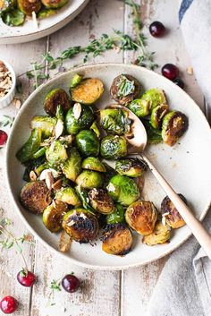 brussel sprouts with mushrooms and cherries in a white bowl on a wooden table