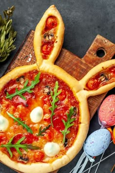 a pizza with toppings on it sitting on top of a cutting board next to other food items