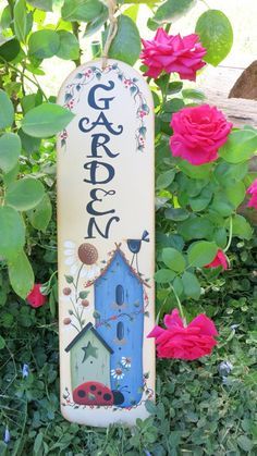 a garden sign hanging from the side of a bush