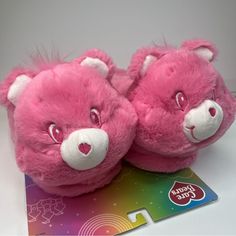 two pink teddy bears sitting next to each other on a card with a rainbow sticker