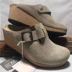 Narrow Fit Fanny Wedge Clog By Papillio. Suede Upper In A Wedge Clog Style With A Round Toe Slip-On Entry Midfoot Strap With Adjustable Metal Buckle Suede Lining With Anatomically Shaped Faux-Leather Footbed Durable Traction Outsole 1.9" Wedge Height Birkenstock Is Committed To Environmentally Friendly Operations. A High Proportion Of The Natural Materials That We Use Are From Sustainable Sources: Cork, Natural Latex, Jute, Leather, Wool Felt, Copper And Brass Are Among Our Most Important Materi Beige Comfortable Slip-on Clogs, Brown Slip-on Clogs With Suede Lining, Spring Clogs With 4-inch Wedge Heel, Suede Slip-on Clogs With Removable Insole, Suede Slip-on Clogs With Buckle Closure, Clogs Style, Black Wedges, Wedge Heel Sandals, Black Sandals Heels