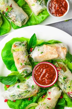 two plates filled with lettuce wrapped in meat and sauces on the side