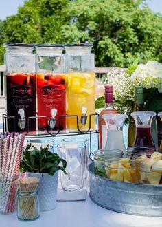 various drinks are lined up on a table next to each other in buckets and cups