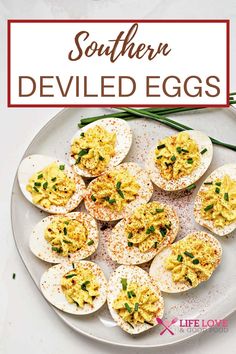 deviled eggs on a white plate with green onions