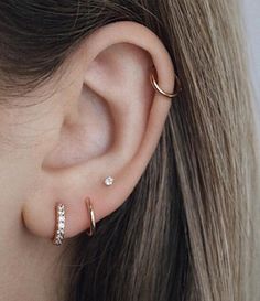 a close up of a person's ear with two different types of piercings