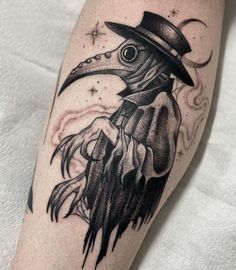 a bird with a hat on its head is shown in black and grey ink, sitting on a person's leg