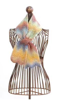 a multicolored knitted scarf on top of a mannequin