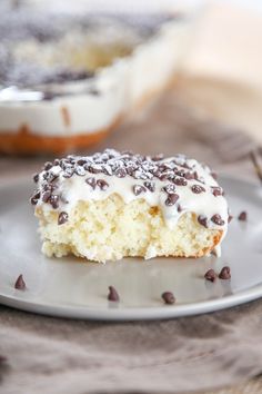 a piece of cake with white frosting and chocolate sprinkles on a plate