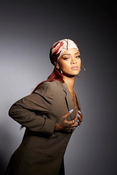 a woman in a suit and head scarf posing for a photo with her hands on her hips