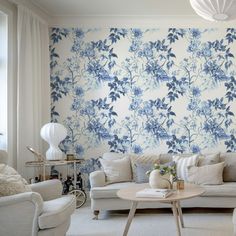 a living room with blue and white wallpaper on the walls next to two couches