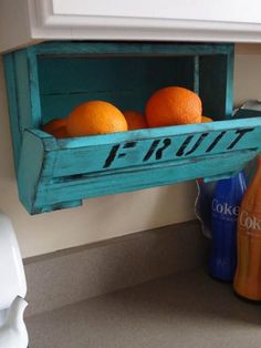 an old crate with fruit in it is hanging on the wall next to a bottle