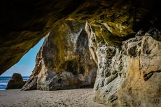 a large rock formation sitting on top of a sandy beach