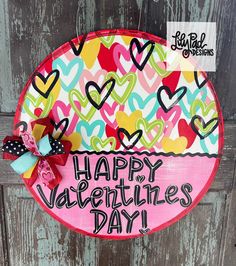 a happy valentine's day sign hanging on the side of a wooden door with hearts