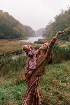 a woman holding a child up in the air