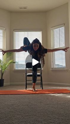 a woman is doing yoga on an orange mat in the middle of a living room