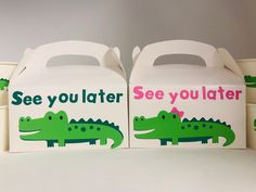 two white boxes with green and pink alligators on them, one is for see you later