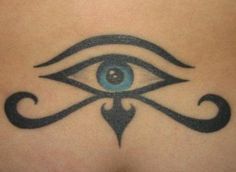 an eye tattoo on the back of a woman's stomach