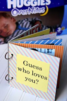 a close up of an open book on a table with a sign that says guess who loves you?