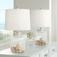 two lamps sitting on top of a white table