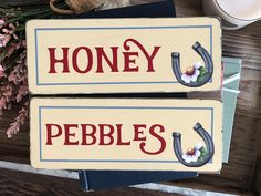 two wooden signs with the words honey and pebble's on them next to flowers