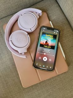 a cell phone sitting on top of a table next to headphones