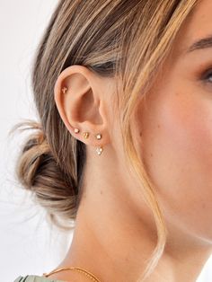 a close up of a woman wearing gold earring and necklace with diamond studs