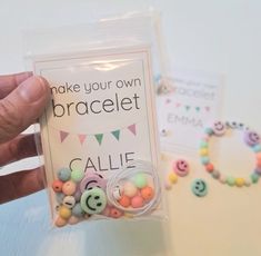 a person holding up a bag of beads with the words make your own bracelet written on it