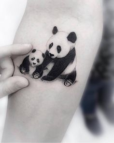 a panda bear and cub tattoo on the arm