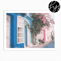 a blue and white building with pink flowers on the outside, and a man walking down the street