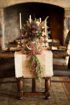 the table is set with flowers and candles