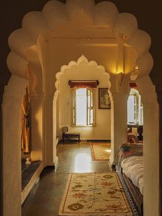 an archway leading into a bedroom with a large rug on the floor