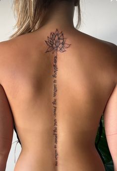 the back of a woman's neck with a lotus tattoo on it