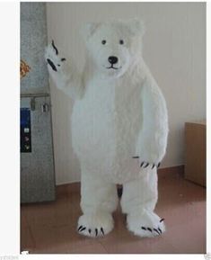 a large white polar bear standing in the middle of a room next to a wall