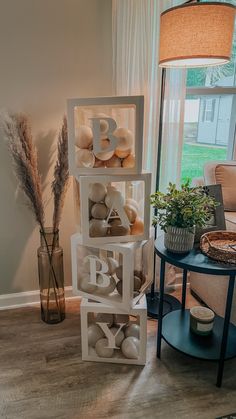 a stack of letter blocks sitting on top of a wooden floor next to a window