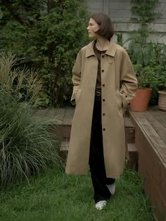 This trench coat is made of a sturdy blend of cotton and polyester for durability, exuding classic sophistication. It features a stand collar and contrasting detail for added interest.- Long length that makes your outfit stylish- Waist belt with buttons cinching the waistline for a feminine silhouette- Stitching details at the collar and sleeves as a refined touch Classic Outerwear With Stand Collar And Double Button Closure, Belted Outerwear With Stand Collar For Work, Classic Khaki Outerwear With Belted Cuffs, Classic Khaki Belted Outerwear, Classic Outerwear With Belted Cuffs, Classic Gabardine Outerwear, Classic Outerwear With Stand Collar And Button Closure, Classic Outerwear With Stand Collar For Work, Classic Brown Outerwear With Belted Cuffs