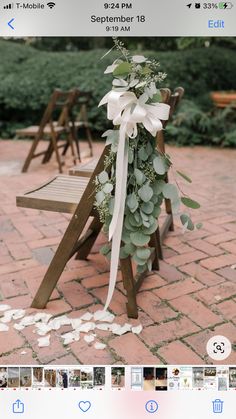 a wooden bench decorated with greenery and white ribbons for a wedding or special event