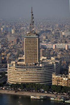 an aerial view of a large building in the middle of a city with lots of tall buildings