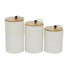 three white ceramic canisters with wooden lids