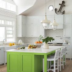 a kitchen with white cabinets and green island