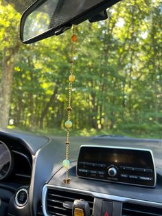 the interior of a car with beads hanging from it's dash board