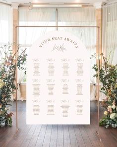 a seating chart is set up in front of floral arrangements