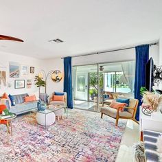 a living room filled with lots of furniture and decor on top of a colorful rug