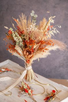 an arrangement of dried flowers in a vase