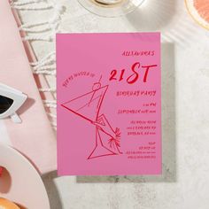 a pink 21st birthday party card sitting on top of a table next to sliced oranges