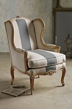 a striped chair sitting on top of a floor next to a mirror in a room