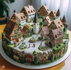 there is a cake that looks like a village with houses on the top of it